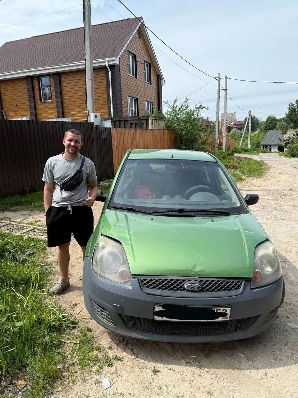 Клиент рядом с автомобилем после сделки